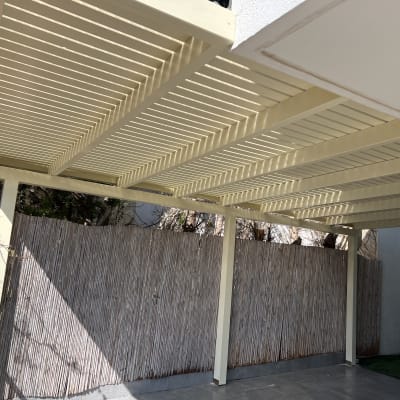 פרגולה מעץ עם גדר במבוק בחצר