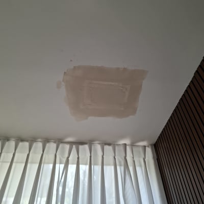 תקרה עם תיקון טיח ליד מנורה ווילון
