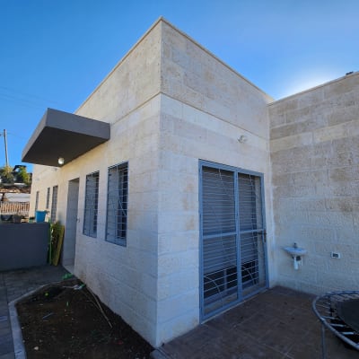 דלת מתכת עם סורגים ליד חלונות עם סורגים