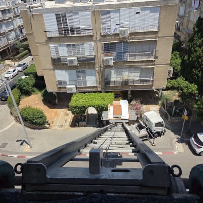 מנוף הרמה מול בניין מגורים בעיר