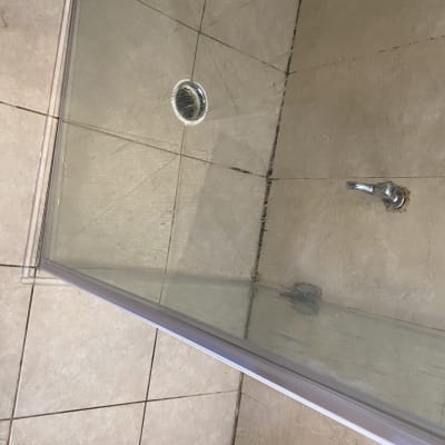 מקלחון עם דלת זכוכית ורצפת אריחים
