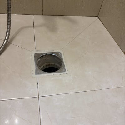 פתח ניקוז פתוח ברצפת מקלחת במהלך עבודת אינסטלציה