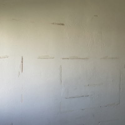 קיר עם סימני שפכטל ותיקונים לפני צביעה