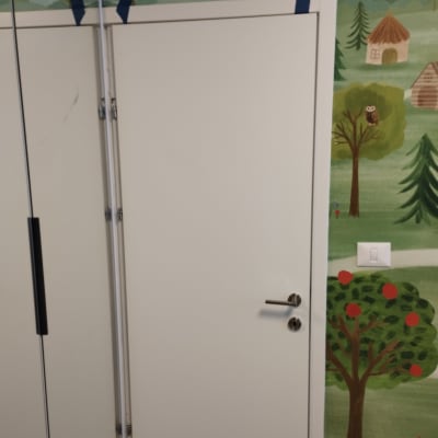 דלת לבנה עם ידית כסופה על רקע קיר מצויר