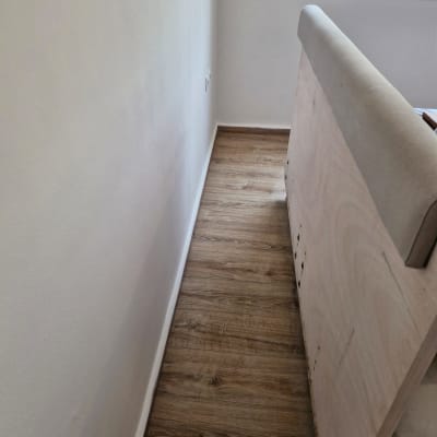 רצפת עץ וקיר לבן בחדר ריק