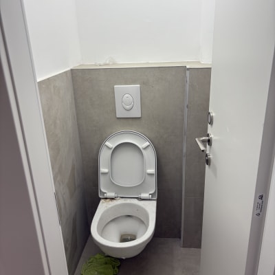 שירותים עם מגבת ירוקה על הרצפה