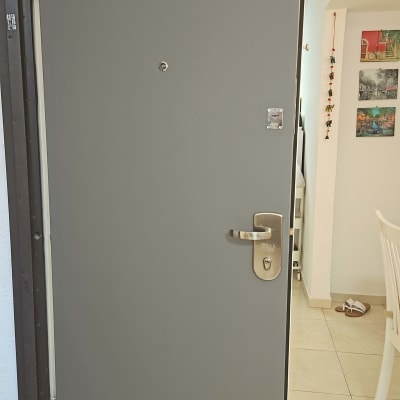 דלת אפורה עם ידית מתכת ומנעול