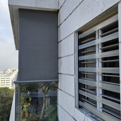 קיר חיצוני עם סדקים ותריסים מתכתיים