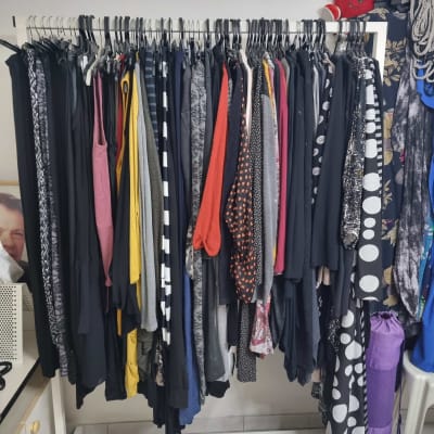 מסגרת בגדים תלויים על מתלה עם קולבים שחורים ולבנים