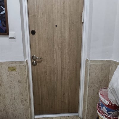 דלת עץ עם ידית מתכת ודליים צבע בצד