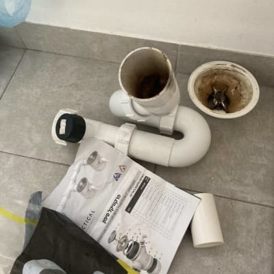 חלקי צנרת פלסטיק על רצפה עם חוברת הוראות