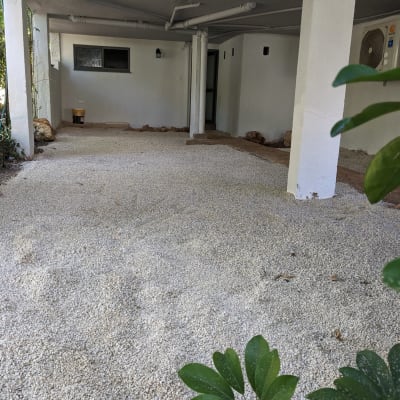 חצץ מפוזר על הקרקע מתחת למבנה עם עמודים