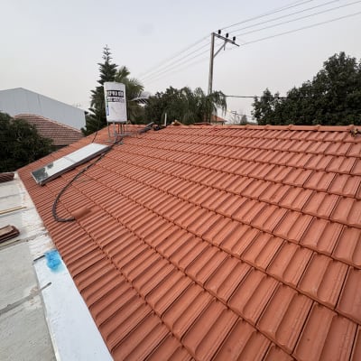 גג רעפים אדום עם דוד שמש וקולטים