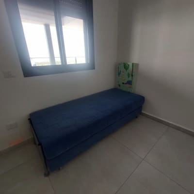 ספה כחולה בחדר עם חלון גדול