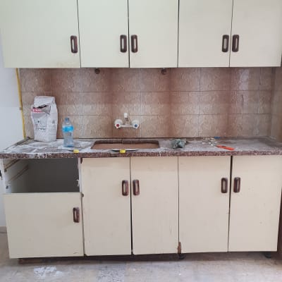 ארון מטבח עם חומרי ניקוי ומטלית על השיש