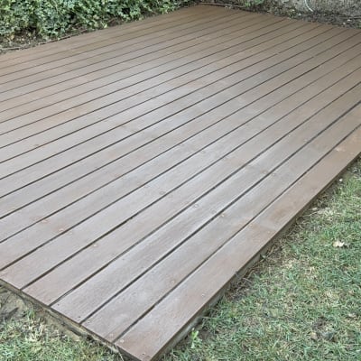 דק עץ בגינה עם צמחייה מסביב