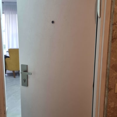 דלת פתוחה עם ידית מתכת וחור הצצה