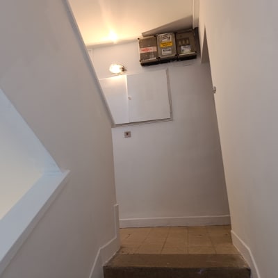 קירות צבועים בלבן במסדרון עם תאורה עליונה