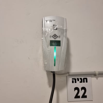 מטען חשמלי על קיר עם שלט חניה