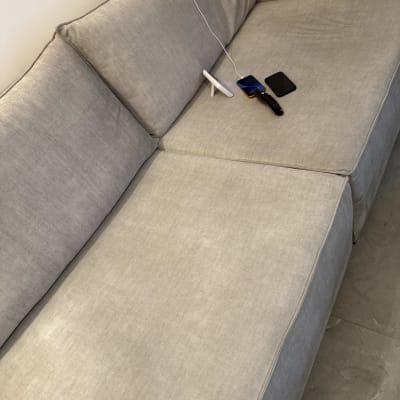 ספה עם שלט וטלפון מונחים עליה