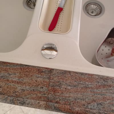 כיור מטבח עם סכין אדומה ומסננת