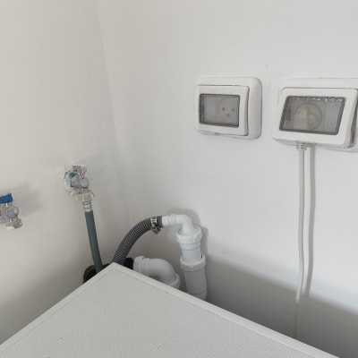 צינורות מים וניקוז עם ברזים בקיר לבן