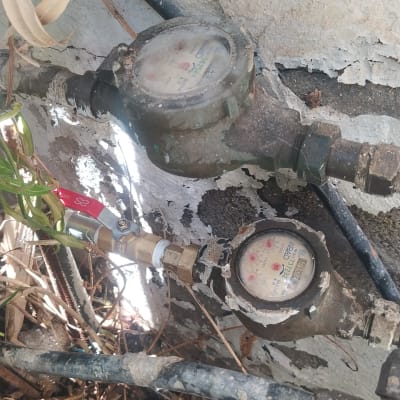 מד מים ישן עם צינורות וברז מתכת