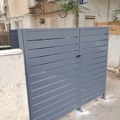 שער מתכת אפור מותקן בחצר בניין