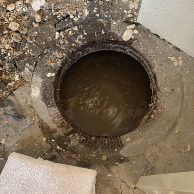 פתח ביוב פתוח עם מים עכורים וסמרטוט לבן