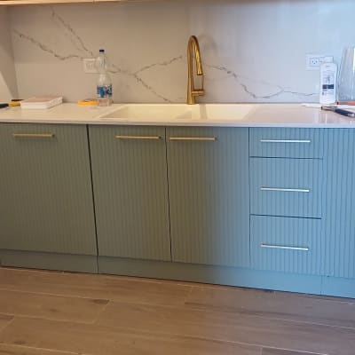 ארונות מטבח ירוקים עם ידיות זהב וברז זהב