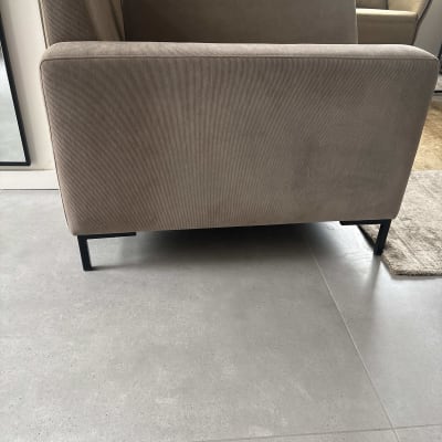 ספה חומה על רצפת אריחים אפורה