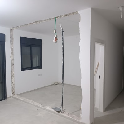 קיר שבור עם חוטי חשמל חשופים במהלך שיפוץ