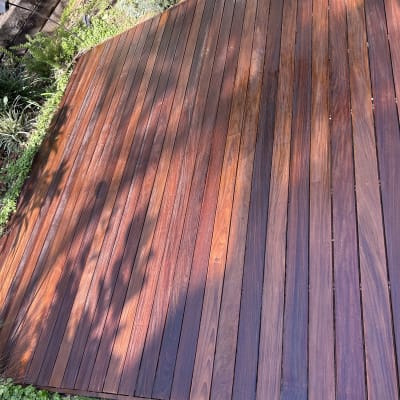 דק עץ בגינה עם צמחייה מסביב