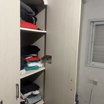 ארון בגדים פתוח עם בגדים מקופלים על מדפים