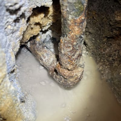 צינור חלוד עם נזילה בתוך קיר