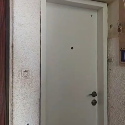 דלת כניסה פלדלת לבנה מותקנת בכניסה לדירה בבניין מגורים