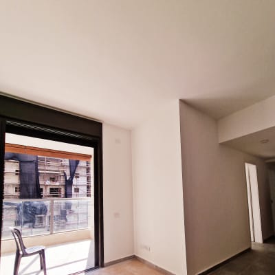 קירות גבס לבנים בחדר עם חלון גדול