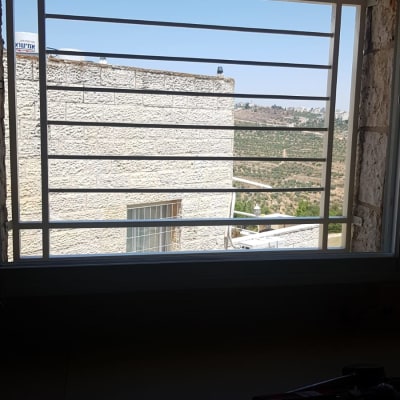 סורגי חלון לבנים עם נוף חיצוני