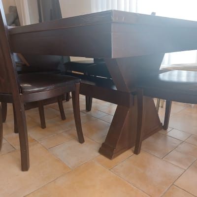 שולחן עץ כהה עם כיסאות תואמים על רצפת אריחים