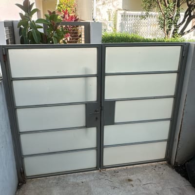 שער זכוכית בחצר עם צמחייה מסביב