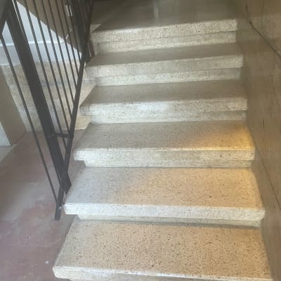 מדרגות שיש עם מעקה מתכת בצד ימין