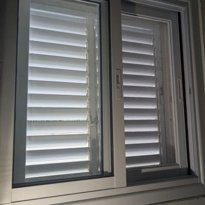 חלון אלומיניום עם תריסים לבנים