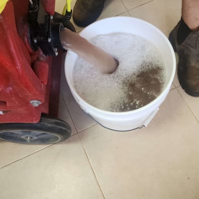 מכונת ניקוי שופכת מים מלוכלכים לדלי