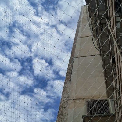רשת שקופה נגד יונים שהותקנה במסתור כביסה בבניין מגורים