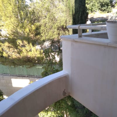 מעקה בטון עם עציץ לבן על מרפסת