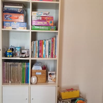 מדף עם משחקי קופסה, ספרים וסל צעצועים