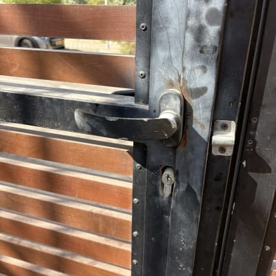 תמונה של ידית דלת מתכתית עם לוחות עץ