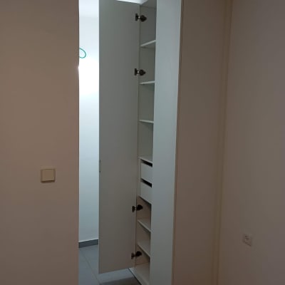 ארון לבן עם דלת פתוחה ומדפים פנימיים