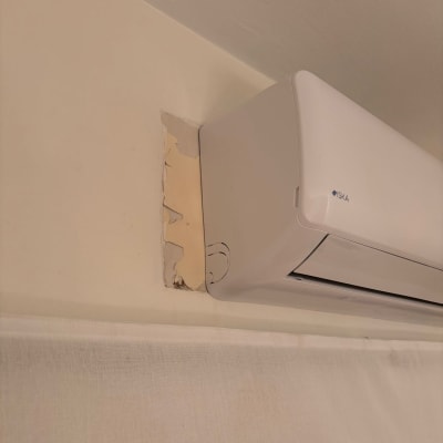 מזגן מותקן על קיר עם קילוף צבע