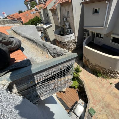 גג עם רשת למניעת כניסת יונים ליד בתים